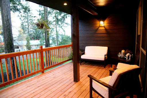 A cozy porch with comfortable seating, surrounded by nature.