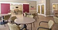 An empty dining room with round tables and chairs arranged neatly.