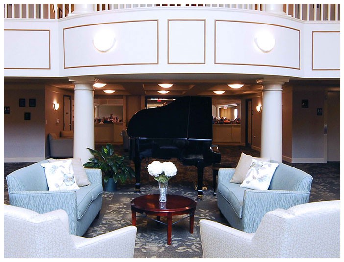 An elegant lobby with a grand piano and comfortable seating area.