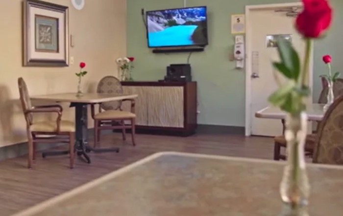 A cozy restaurant interior with tables, chairs, and a television on the wall.
