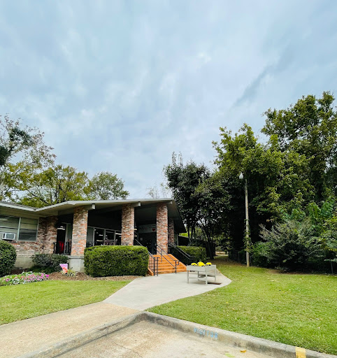 A charming house set amidst lush greenery under a cloudy sky.