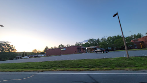 A serene view of a building at sunset, with parked vehicles in the foreground.