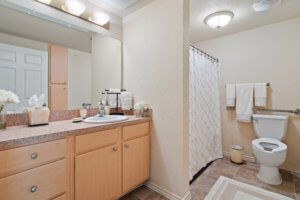 A clean and modern bathroom with a large mirror and a shower area.