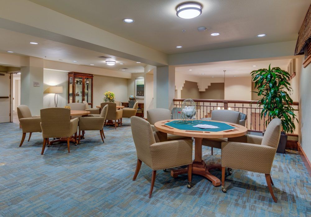 A cozy lounge area featuring a round table with chairs and soft lighting.
