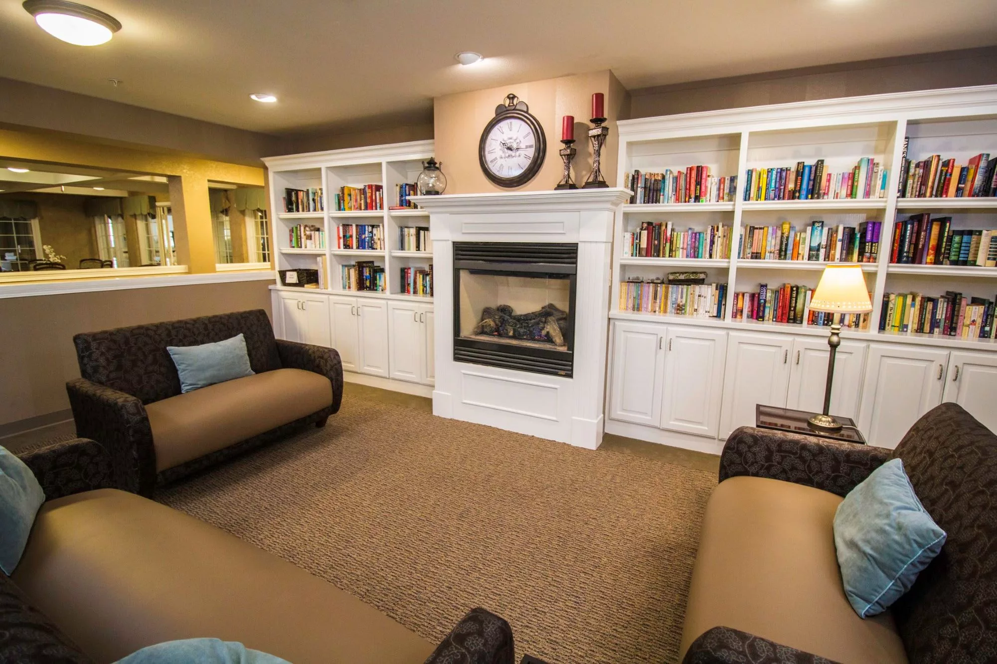 Cozy living room with a fireplace surrounded by bookshelves and comfortable seating.