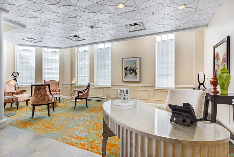 A well-lit office waiting area with a desk and chairs.