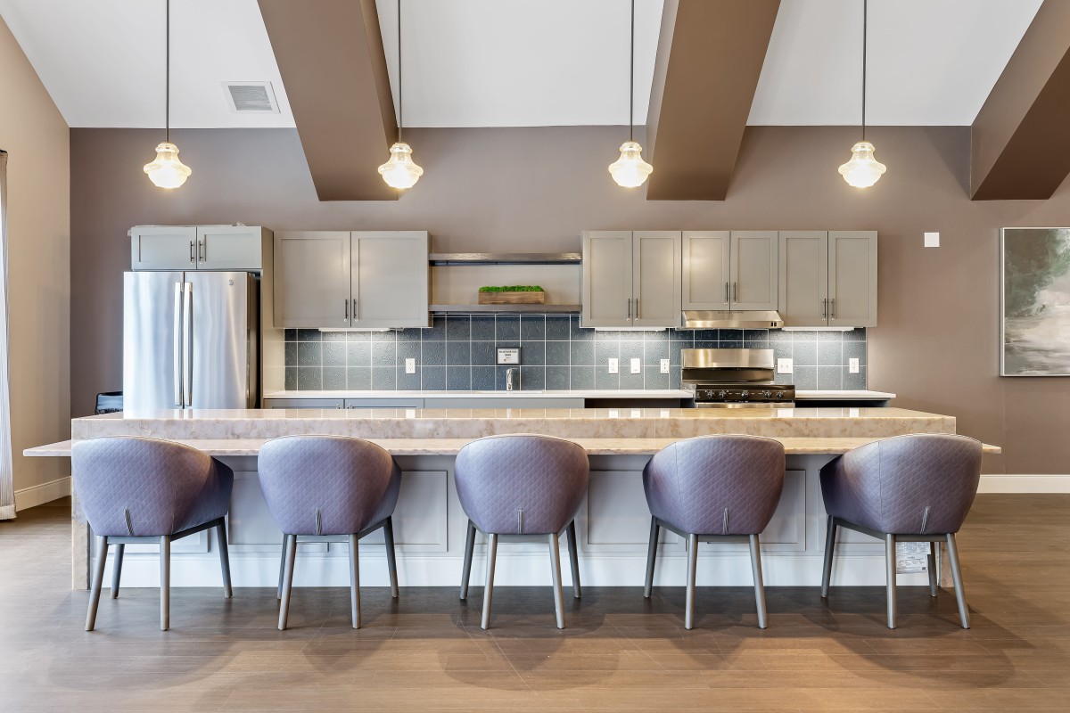 Modern kitchen with bar seating and elegant lighting.