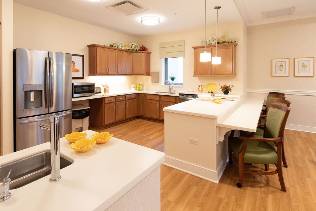 A modern kitchen with wooden cabinets and a cozy island for seating.