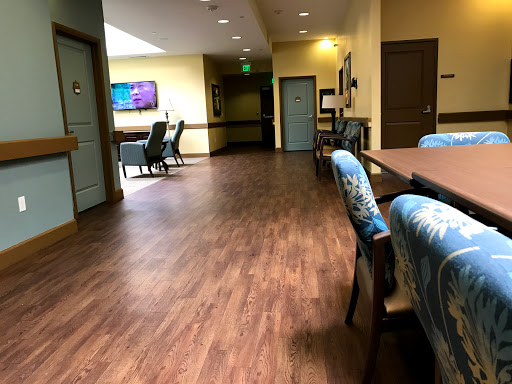 A well-lit hallway featuring a spacious layout with chairs and a table, ideal for gatherings or meetings.