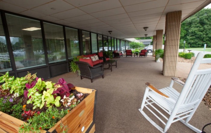A welcoming outdoor patio area with cozy seating and lush plants.