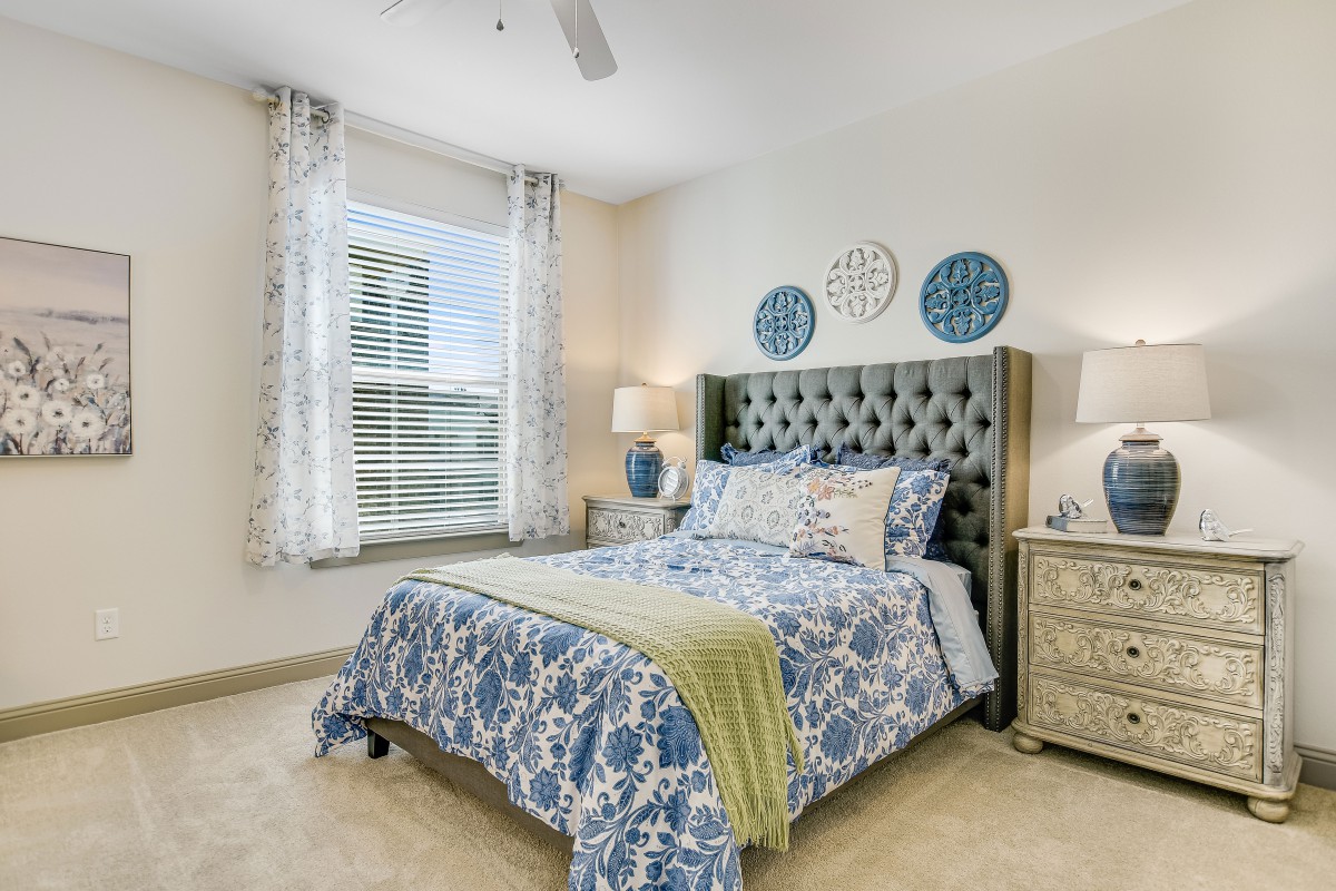 A well-decorated bedroom with a stylish headboard and matching bedding.