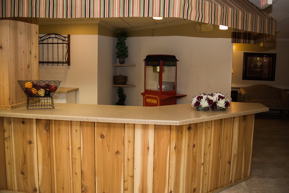 A reception area with a wooden counter and a popcorn machine in the background.