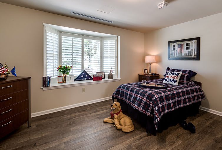 A cozy bedroom with a window seat, featuring a neatly made bed and stylish decor.