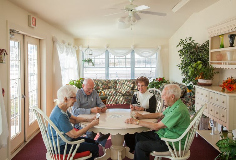 A group of seniors enjoying a card game together indoors.