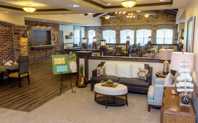 A cozy living room with modern decor, featuring a comfortable couch, coffee table, and ample natural light from large windows.