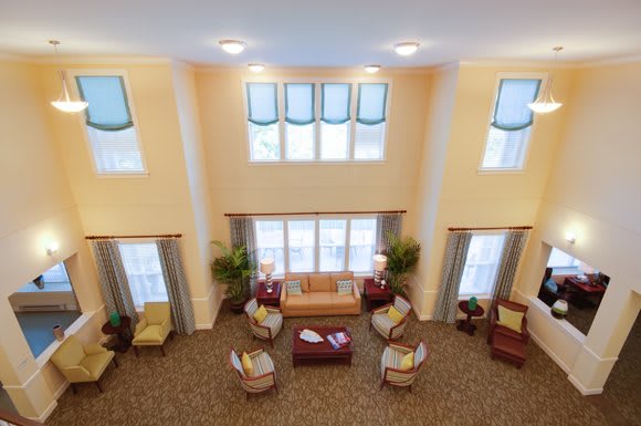 A spacious living room with multiple seating areas and large windows.