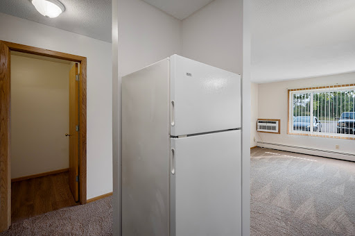 A glimpse into a modern kitchen featuring a white refrigerator and an open living area.