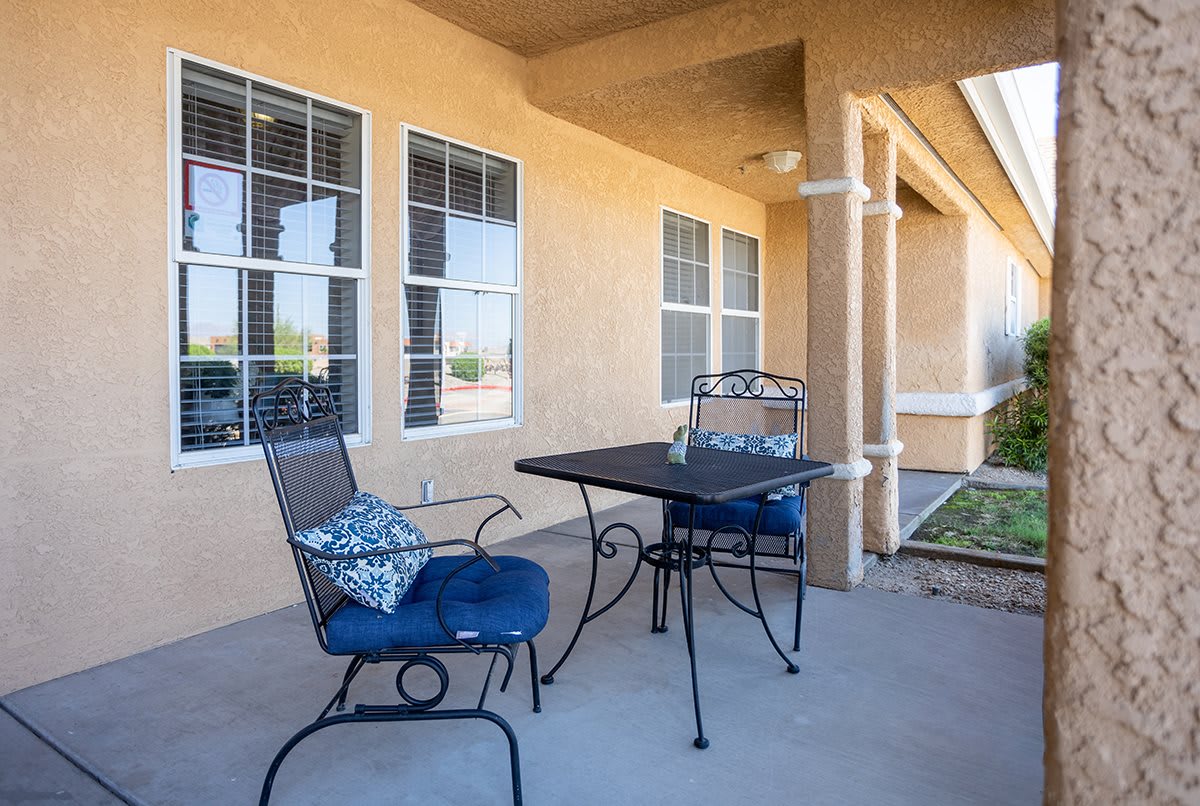 A cozy patio setup with a table and two cushioned chairs.