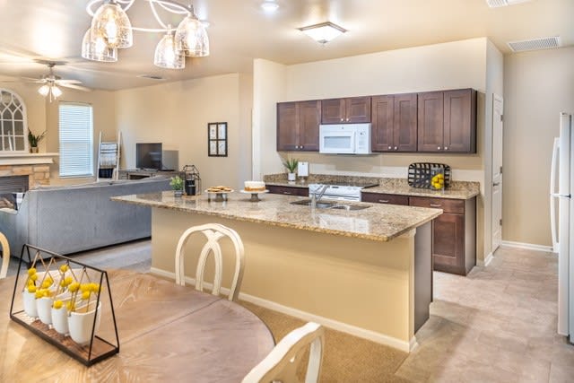 A modern kitchen with an open-plan design featuring an island counter and dining area.