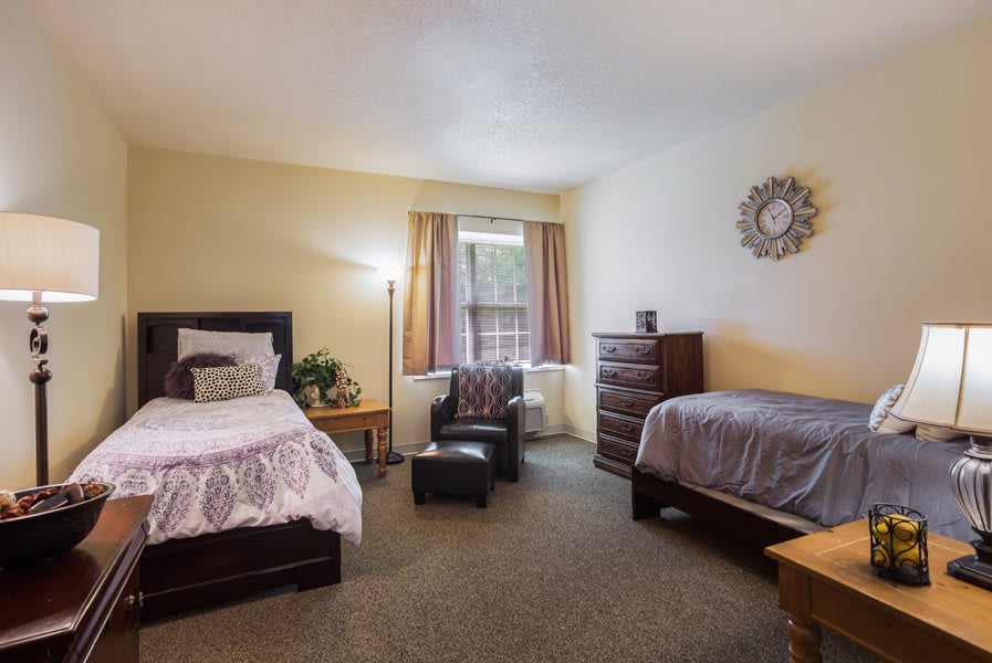 A cozy bedroom with two beds, a window, and stylish decor.