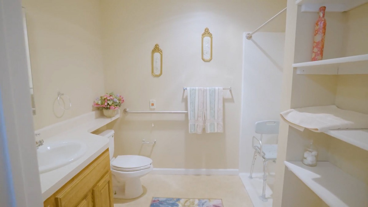 A clean and well-decorated bathroom with a shower and towels.
