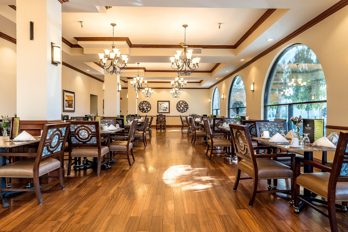 Elegant dining area with chandeliers and wooden flooring.