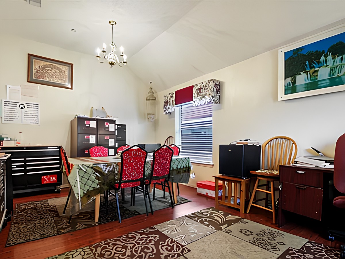 A cozy dining room with a large table, colorful chairs, and decorative elements.