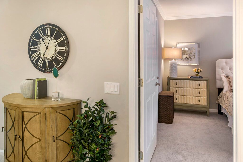 A cozy living space featuring a wall clock, cabinet, and stylish lighting.