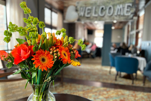 A vibrant bouquet of flowers welcomes guests in a cozy interior setting.