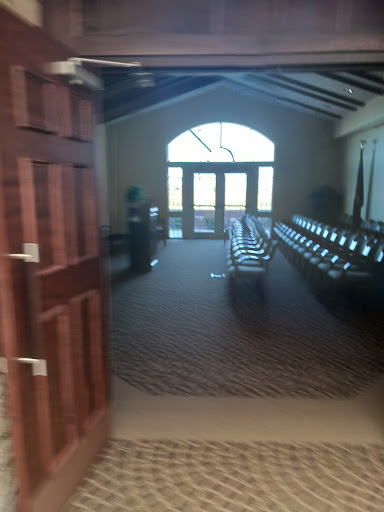 A view of a spacious conference room with seating arranged for an event, illuminated by natural light from large windows.