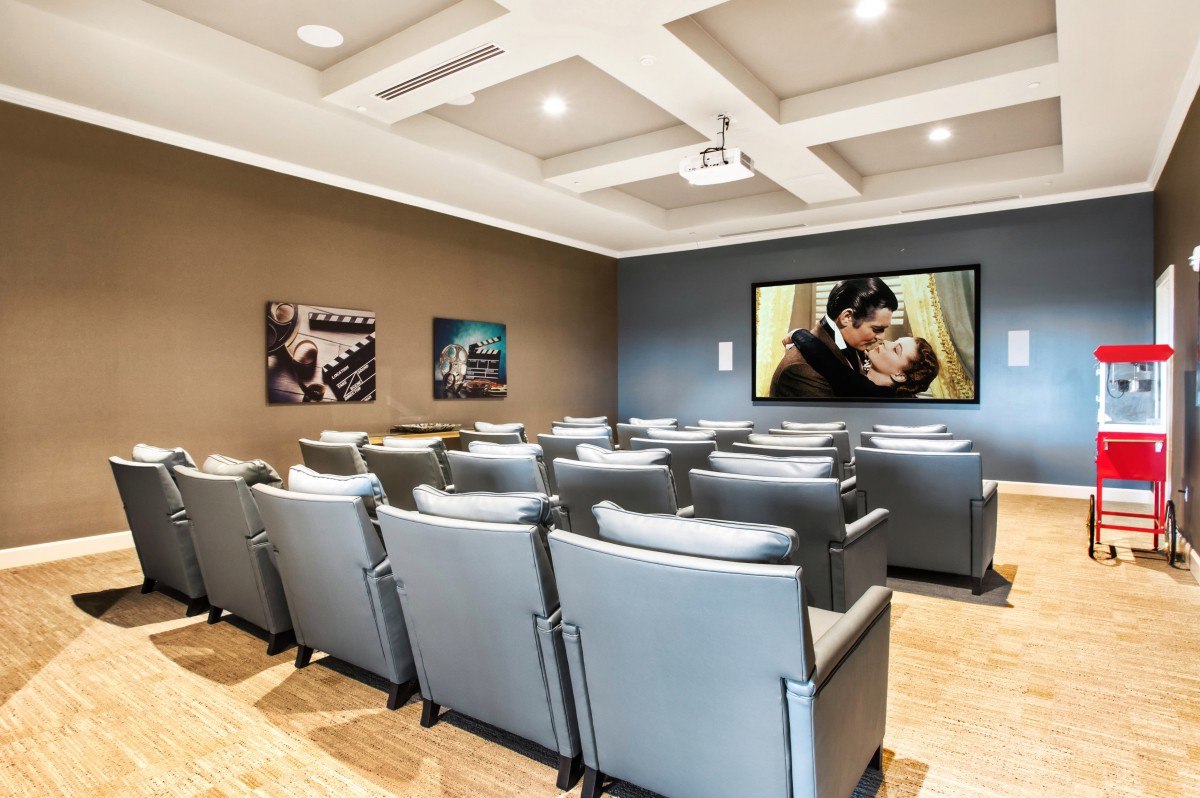 A cozy home theater with plush seating and a large projector screen.