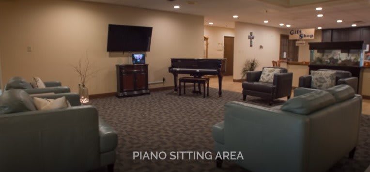 A cozy sitting area with a piano and television.