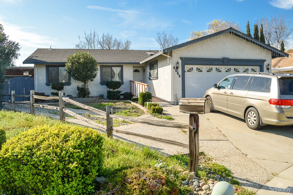 A suburban house with a driveway leading to a garage and well-maintained front yard.