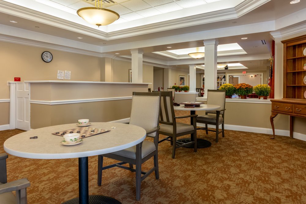 A cozy dining area with neatly arranged tables and chairs, featuring warm lighting and tasteful decor.