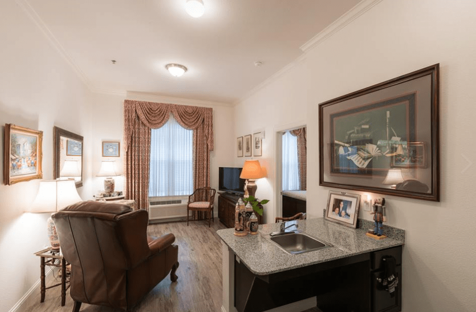 Cozy living room with elegant decor, featuring a chair, lamps, and framed artwork.