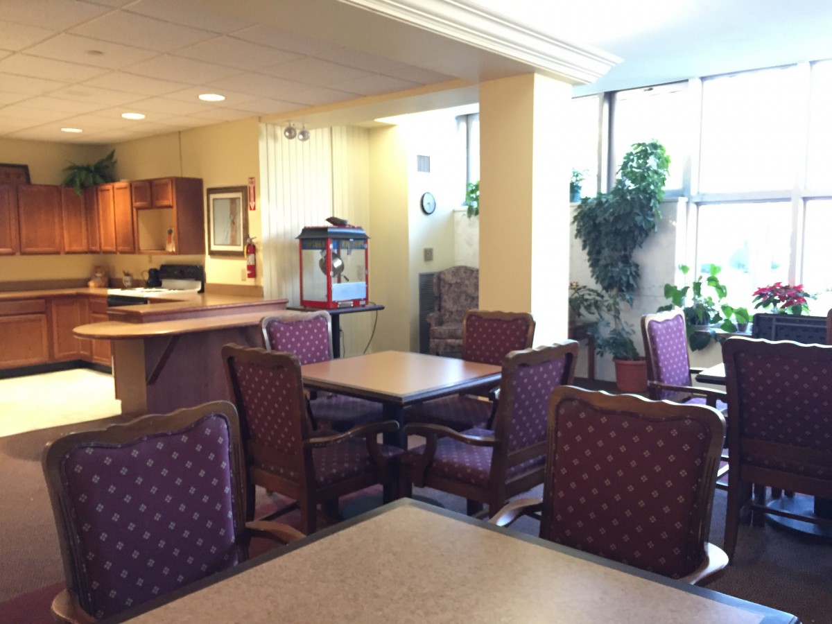 A brightly lit dining area with multiple tables and chairs.