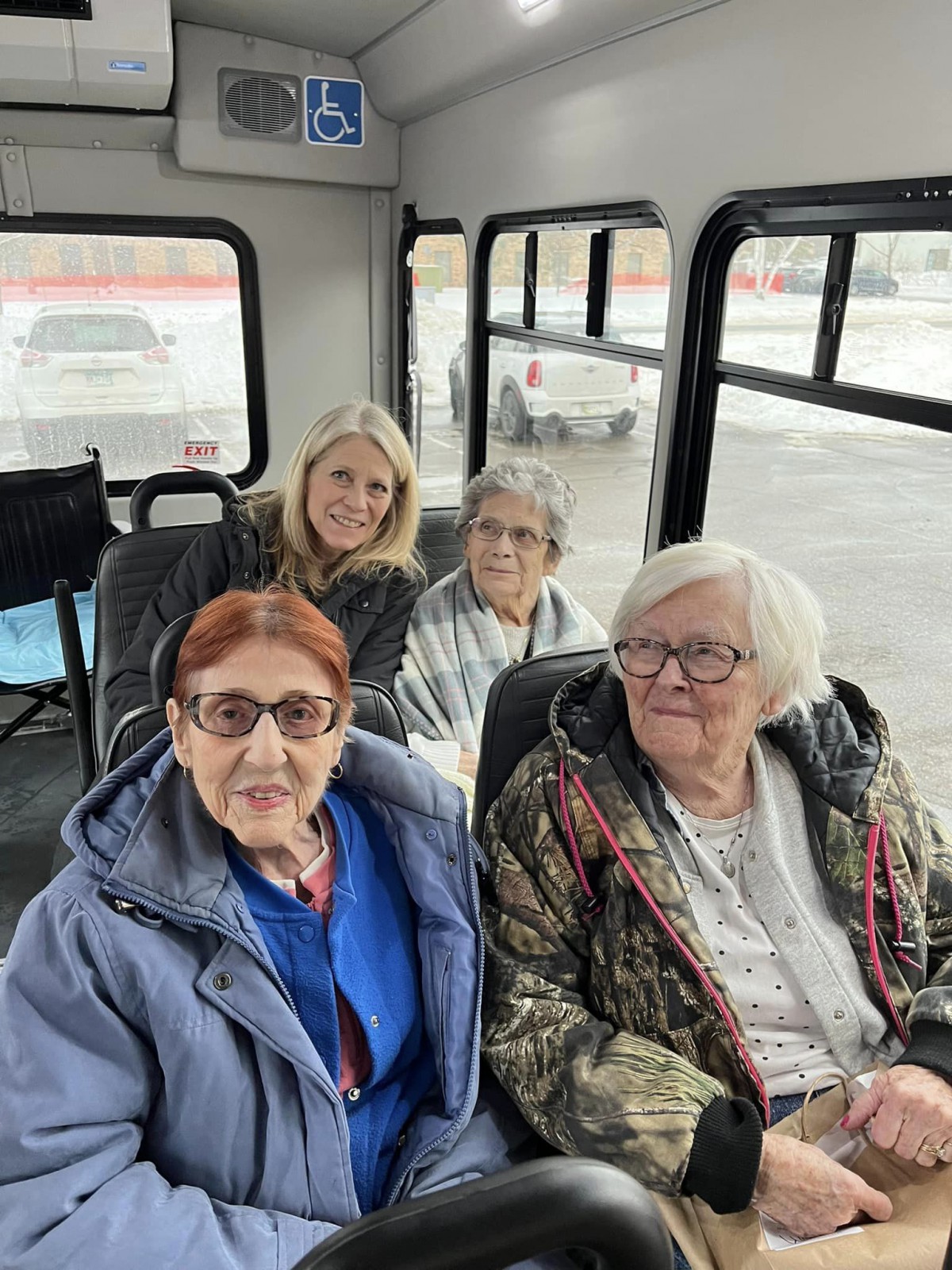 A group of four women seated inside a bus.