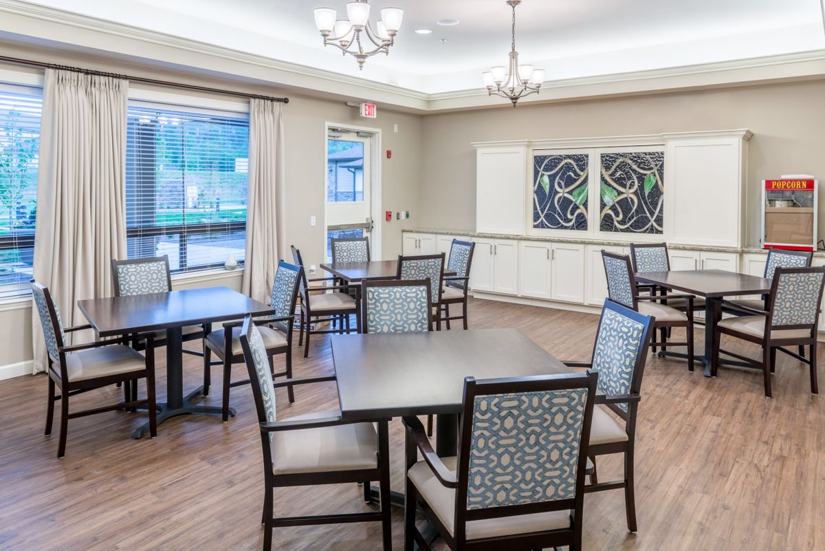 An elegant dining room with neatly arranged tables and chairs, featuring stylish lighting and wall decorations.