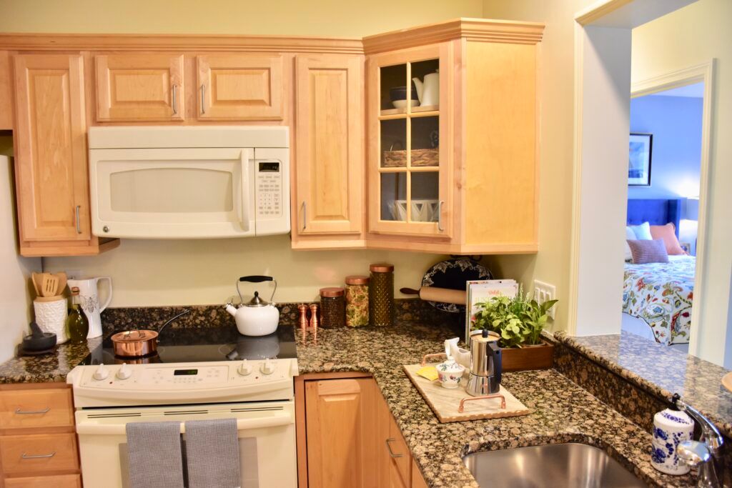 A modern kitchen with wooden cabinets, a microwave, and a granite countertop.