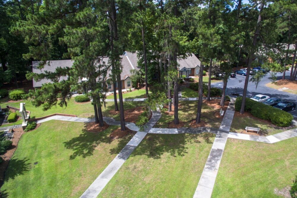 Aerial view of a property surrounded by trees with intersecting pathways.