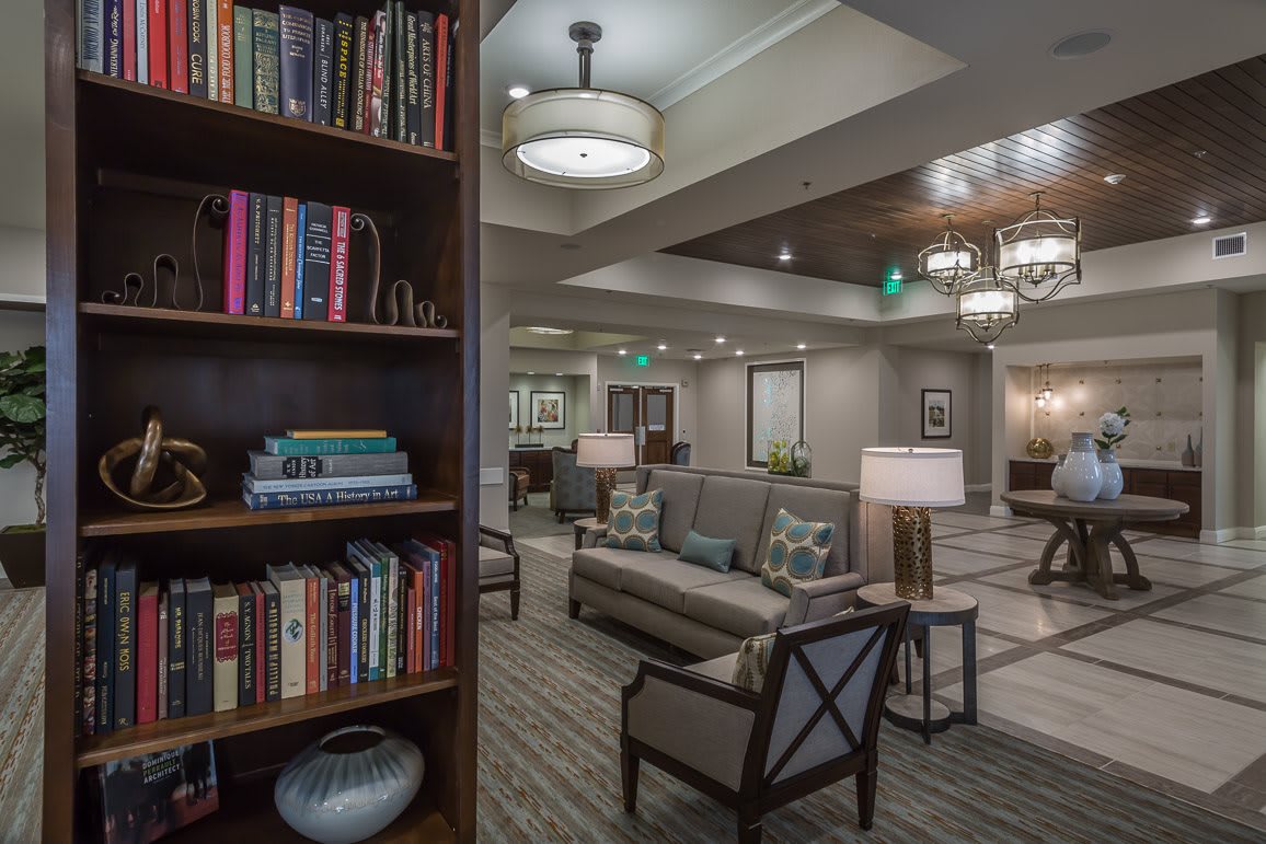 A modern lounge area with a bookshelf and comfortable seating.