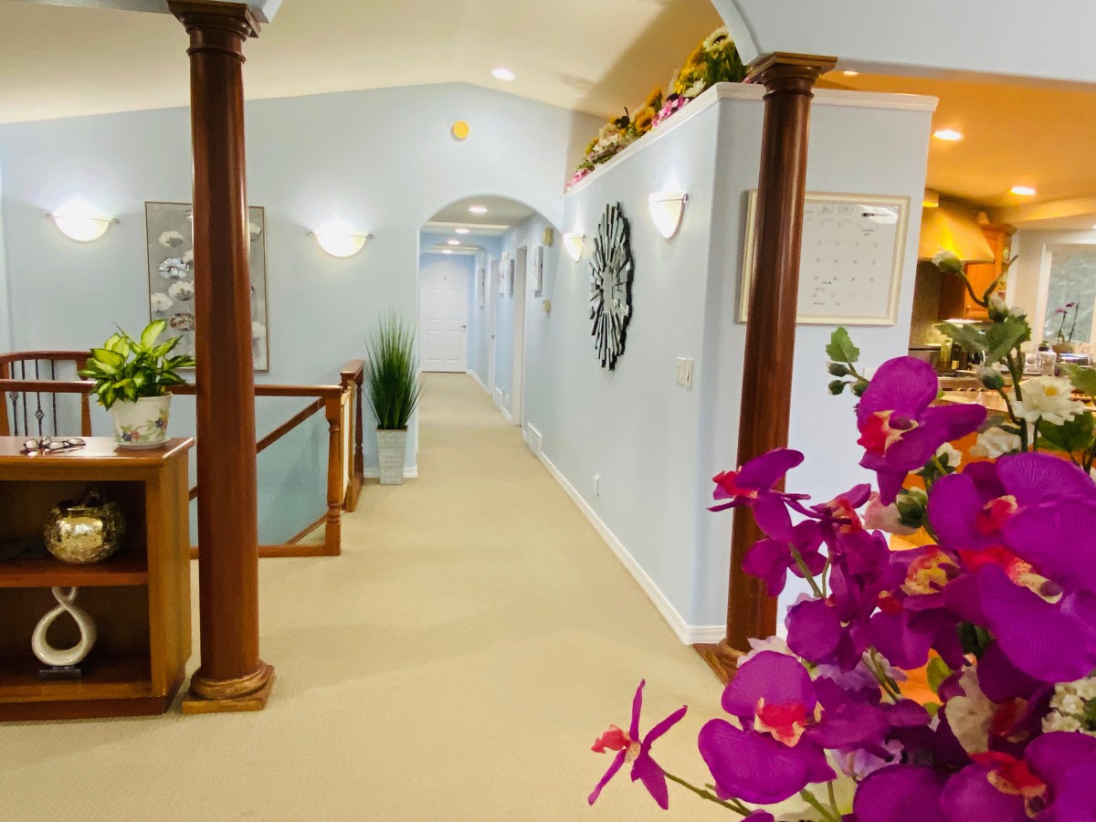 A stylish hallway with decorative columns, vibrant flowers, and elegant interior design.
