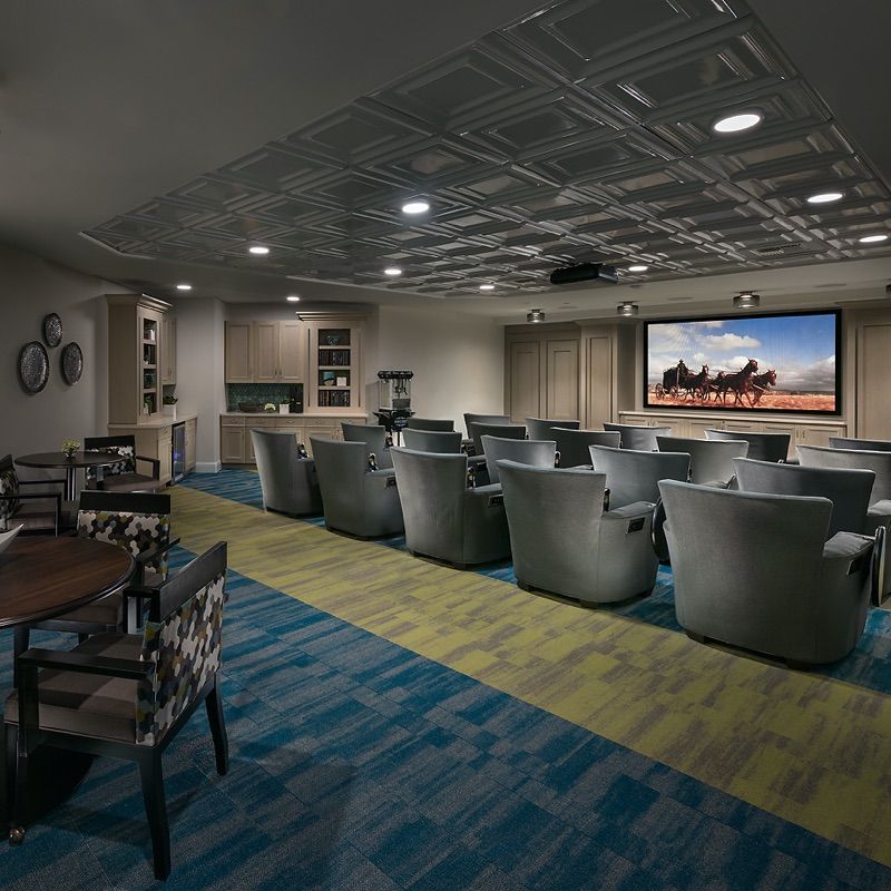 A cozy home theater room with rows of comfortable seating and a large screen for movie viewing.