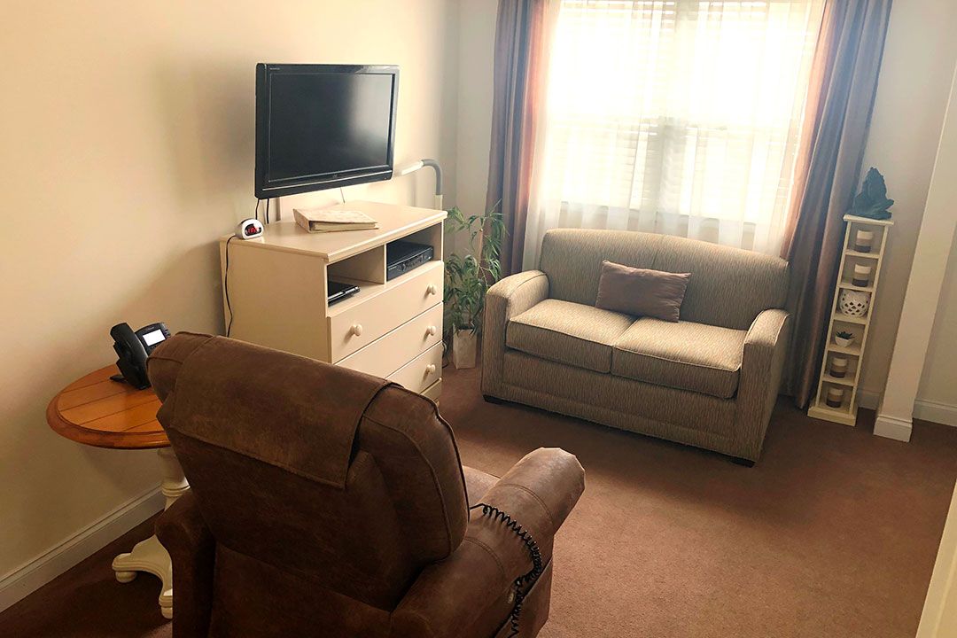 Cozy living room with a sofa, armchair, and television.
