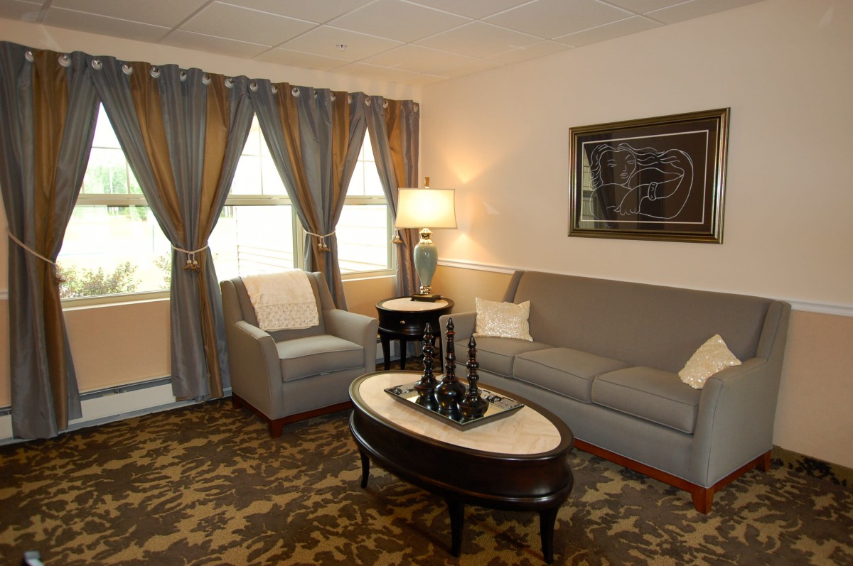 A cozy living room with a sofa, armchair, and elegant decor.