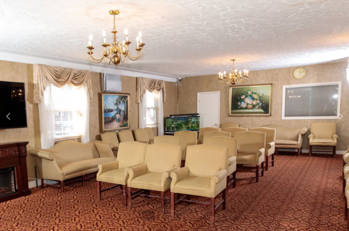 A furnished room with arranged seating and decorative paintings.