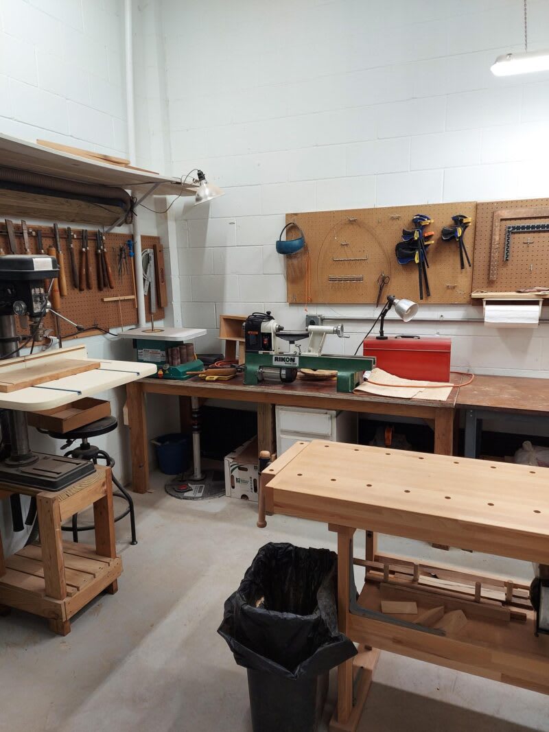 A well-organized woodworking workshop with various tools and workbenches.