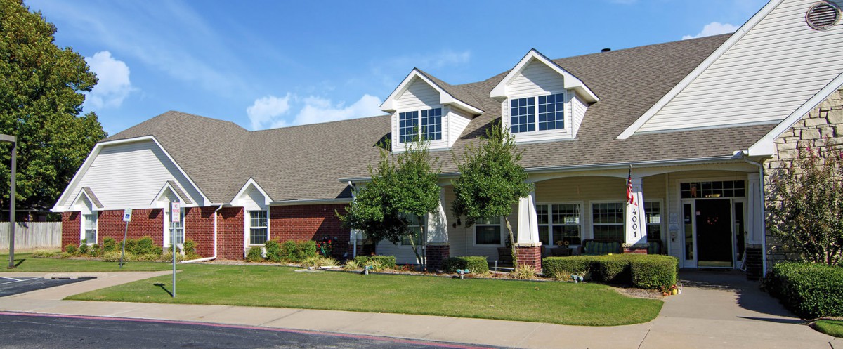 A suburban house with a well-maintained front yard and trees.