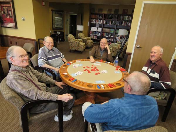 A group of seniors enjoying a card game together around a table.