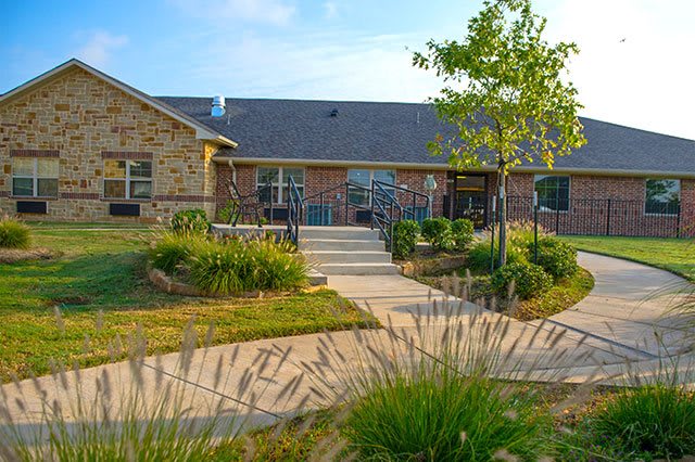 A charming house with a well-landscaped garden and a pathway leading to the entrance.